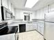 Bright kitchen features white cabinets, modern appliances and tile flooring at 322 S Dixon Ave, Cary, NC 27511