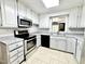 Updated kitchen boasts stainless steel appliances, white cabinets, and backyard view at 322 S Dixon Ave, Cary, NC 27511