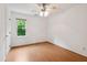 Empty bedroom with light wood flooring, neutral walls, and a window with green outdoor views at 3405 E Jameson Rd, Raleigh, NC 27604