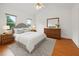 Inviting bedroom featuring a queen bed, wood floors, minimalist décor, and ample natural light at 3405 E Jameson Rd, Raleigh, NC 27604