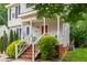 Charming front porch with decorative railings and red front door, creating a welcoming entrance at 3405 E Jameson Rd, Raleigh, NC 27604