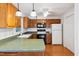Kitchen featuring wood cabinets, green countertops, white appliances, and wood flooring at 3405 E Jameson Rd, Raleigh, NC 27604