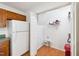 Laundry room includes a refrigerator, storage shelving, and a red trash can at 3405 E Jameson Rd, Raleigh, NC 27604