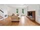 Inviting living room featuring wood floors, a cozy fireplace, and abundant natural light at 3405 E Jameson Rd, Raleigh, NC 27604