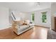 Bright living room featuring hardwood floors, a brick fireplace, and natural light at 3405 E Jameson Rd, Raleigh, NC 27604