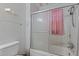 Compact bathroom featuring a tiled shower with sliding glass door and a pink shower curtain at 345 Henderson St, Oxford, NC 27565