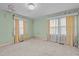 Bedroom featuring soft carpet, two windows with curtains, and mint-green walls at 345 Henderson St, Oxford, NC 27565