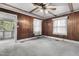 Wood-paneled bedroom with windows, ceiling fan, and access to a bright sunroom at 345 Henderson St, Oxford, NC 27565