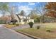 Inviting two-story yellow home featuring a spacious driveway and well-maintained landscaping and mature trees at 345 Henderson St, Oxford, NC 27565