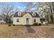 Charming yellow cottage-style home with dormer windows and a landscaped front yard in a beautiful autumnal setting at 345 Henderson St, Oxford, NC 27565