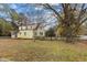 Inviting two-story yellow home with a classic picket fence and lush surroundings at 345 Henderson St, Oxford, NC 27565