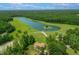 Aerial view of lake with small island, boat ramp, and manicured lawn at 390 Lake Magnolia Way, Smithfield, NC 27577