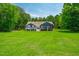 Lake house surrounded by a sprawling lawn and mature trees at 390 Lake Magnolia Way, Smithfield, NC 27577