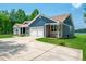 Scenic home exterior showcasing lush lawn, stone accents, driveway, and two-car garage at 390 Lake Magnolia Way, Smithfield, NC 27577