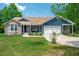 Charming single-story home featuring stone accents, a two-car garage, and a well-manicured lawn at 390 Lake Magnolia Way, Smithfield, NC 27577