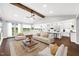 Bright, open living room with cathedral ceiling and exposed wood beam open to modern kitchen at 390 Lake Magnolia Way, Smithfield, NC 27577