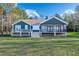 Charming rear exterior featuring a stone foundation and inviting deck with steps to the lush lawn at 390 Lake Magnolia Way, Smithfield, NC 27577