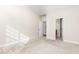 This bedroom features a doorway to the bathroom next to a white wall, and beige carpet throughout the room at 4110 Argyle Trl, Burlington, NC 27215