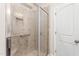 This shower features a glass door with a handheld shower head, next to a white door at 4110 Argyle Trl, Burlington, NC 27215
