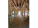 Unfinished entryway showcasing the framing and construction with an open door at the end at 432 Golden Dragonfly St, Wake Forest, NC 27587