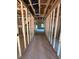 Unfinished hallway with exposed wiring and wooden beams leads to a living area with natural light at 432 Golden Dragonfly St, Wake Forest, NC 27587