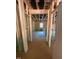 Unfinished hallway displays wooden beams, wiring, and leads towards an area with a window at the end at 432 Golden Dragonfly St, Wake Forest, NC 27587