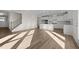 Open-concept living area featuring wood floors, a staircase, and a modern kitchen with an island at 432 Golden Dragonfly St, Wake Forest, NC 27587