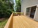 View of the wood deck, with access via a sliding glass door to the home's interior at 4903 Bridgewood Dr, Durham, NC 27713