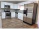Well-appointed kitchen with stainless steel appliances, granite countertops, white cabinets, and wood-look flooring at 4903 Bridgewood Dr, Durham, NC 27713