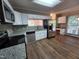 Modern kitchen featuring stainless steel appliances, granite countertops, white cabinetry, and wood-look flooring at 4903 Bridgewood Dr, Durham, NC 27713