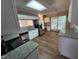 Bright kitchen with granite countertops, stainless steel appliances, white cabinets, and wood-look flooring at 4903 Bridgewood Dr, Durham, NC 27713