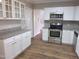 Updated kitchen with granite countertops, white cabinets, stainless steel appliances, and wood-look flooring at 4903 Bridgewood Dr, Durham, NC 27713