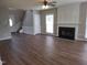 Open living room with wood floors, fireplace, and staircase for a welcoming space at 4903 Bridgewood Dr, Durham, NC 27713