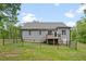 Home exterior showcasing a fenced backyard, deck, and well-maintained lawn backing to mature trees at 50 Harriet Gentry Ln, Timberlake, NC 27583