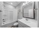 Clean bathroom featuring a tub/shower combo, white vanity, a decorative mirror, and sleek fixtures at 50 Harriet Gentry Ln, Timberlake, NC 27583