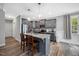 Well-lit kitchen with gray cabinets, granite counters, stainless steel appliances, and a kitchen island with bar stool seating at 50 Harriet Gentry Ln, Timberlake, NC 27583