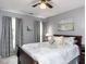 Cozy bedroom featuring soft gray walls, plush bedding, and natural light from the window at 5009 Beckwyck Dr, Fuquay Varina, NC 27526