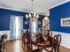 Elegant dining room with blue walls and decorative chandelier at 5009 Beckwyck Dr, Fuquay Varina, NC 27526