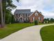 Elegant brick home featuring a long driveway and well-maintained landscaping at 5009 Beckwyck Dr, Fuquay Varina, NC 27526