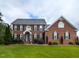 Stately brick home with manicured lawn, dark shutters, and a welcoming blue front door at 5009 Beckwyck Dr, Fuquay Varina, NC 27526