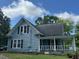 Two story home with porch, vinyl siding and black shutters, and well maintained lawn at 509 W Rose St, Sanford, NC 27330