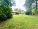 Large, inviting backyard space with lush green lawn framed by mature trees, creating a private retreat at 518 Heater Dr, Cary, NC 27511