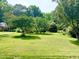 Beautiful, expansive front yard featuring mature trees and a well-manicured lawn, offering privacy and curb appeal at 518 Heater Dr, Cary, NC 27511
