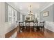 Elegant dining room featuring wainscoting, plantation shutters, and a stylish chandelier at 5516 Colonial Oaks Dr, Apex, NC 27539