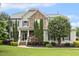 Charming home featuring a stone facade, manicured lawn, and inviting front porch at 5516 Colonial Oaks Dr, Apex, NC 27539