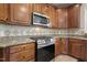 Close-up view of the kitchen with granite countertops, wooden cabinets, stainless steel microwave and range at 5516 Colonial Oaks Dr, Apex, NC 27539