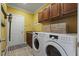 Well-equipped laundry room features ample cabinet space, sink, and modern washer and dryer at 5516 Colonial Oaks Dr, Apex, NC 27539