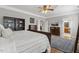 Comfortable main bedroom featuring hardwood floors, ceiling fan, and access to the bathroom at 5516 Colonial Oaks Dr, Apex, NC 27539