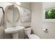Stylish powder room featuring a pedestal sink, oval mirror, and decorative accents at 5516 Colonial Oaks Dr, Apex, NC 27539
