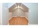 Finished attic space with hardwood floors, built-in shelving, and door to storage at 589 John Mitchell Rd, Youngsville, NC 27596